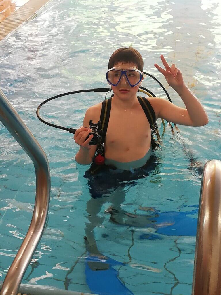 Ein Junge in Taucherausrüstung im Schwimmbad