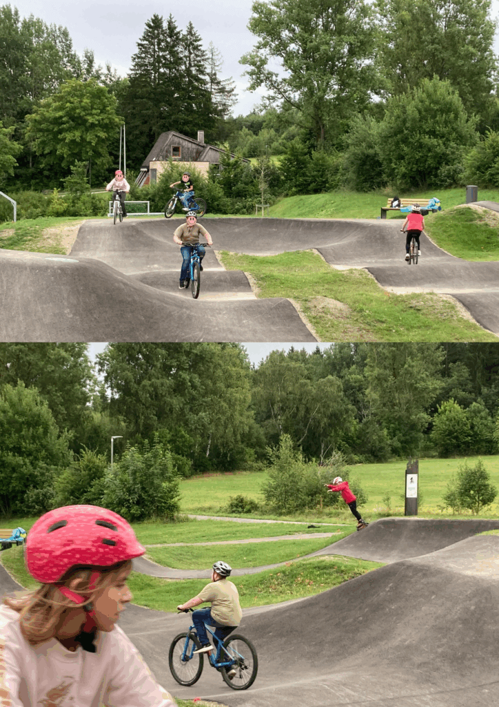 Kinder auf Fahrrädern oder Inlinern fahren über einen hügeligen Pump-Track